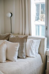 neutral bed with white pillows and neutral european pillows